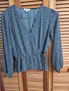 Nine Britton emerald green blouse with a white speckle pattern and a faux wrap